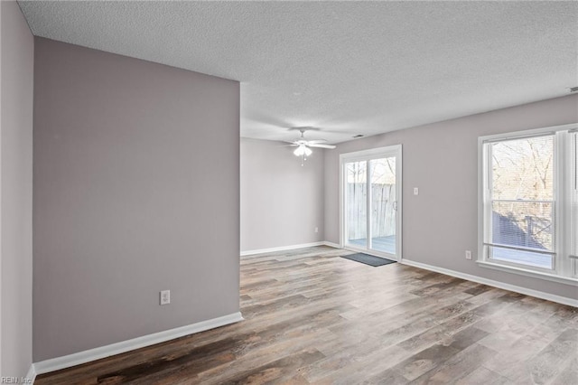 spare room featuring a textured ceiling, wood-type flooring, and ceiling fan