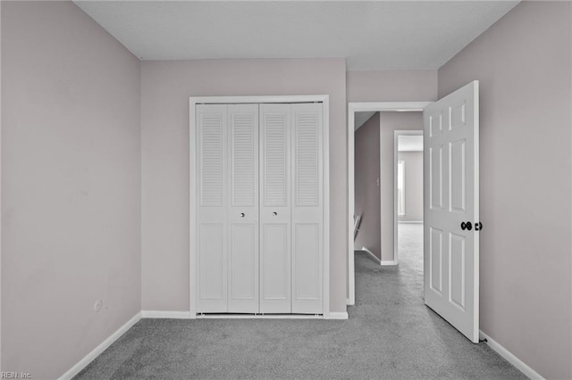 unfurnished bedroom with light colored carpet and a closet