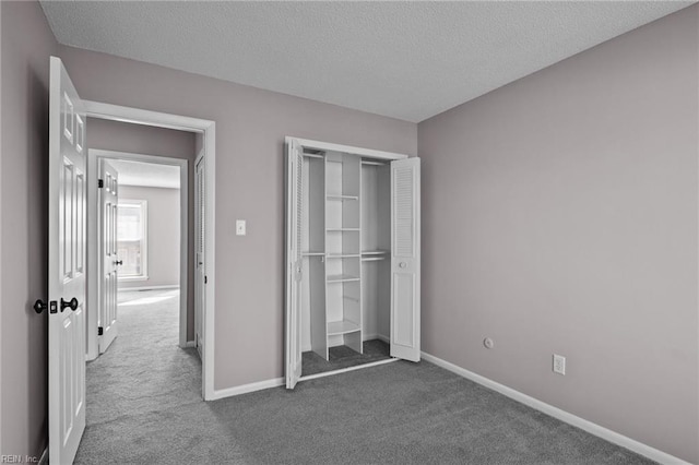 unfurnished bedroom featuring a closet, a textured ceiling, and carpet