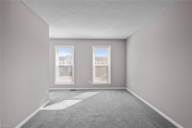 carpeted spare room featuring a textured ceiling