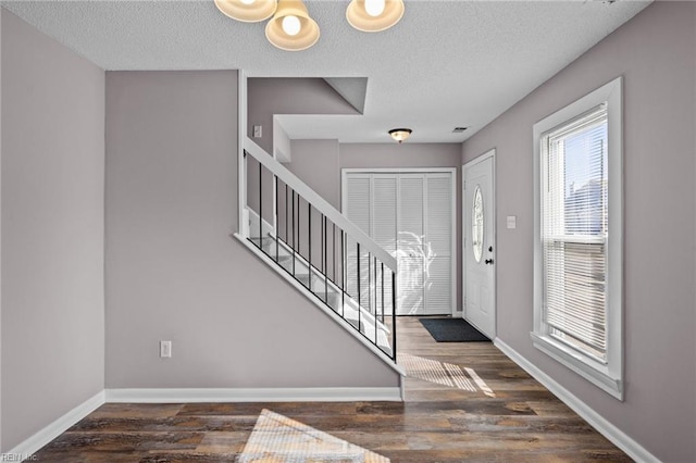 entrance foyer featuring dark wood-type flooring and a textured ceiling