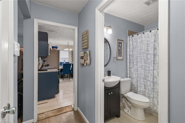 bathroom with vanity, a notable chandelier, toilet, a textured ceiling, and a shower with curtain