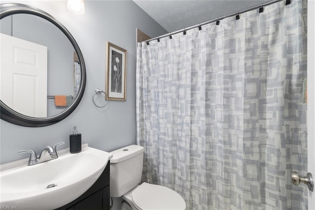 bathroom featuring a shower with curtain, vanity, a textured ceiling, and toilet