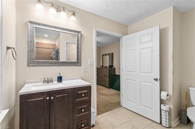 bathroom featuring curtained shower, vanity, toilet, tile patterned floors, and a textured ceiling