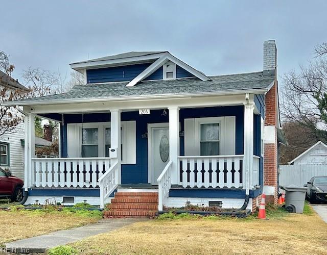 bungalow-style home featuring covered porch and a front yard