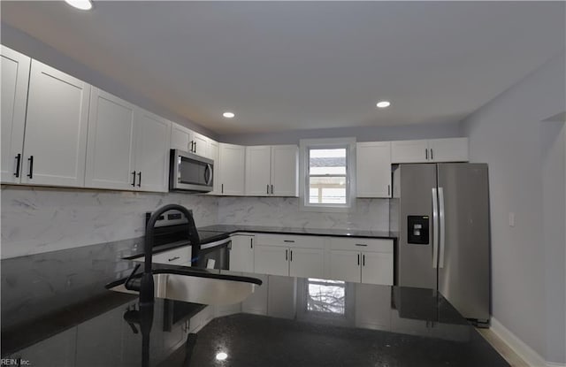 kitchen featuring white cabinetry, appliances with stainless steel finishes, sink, and backsplash