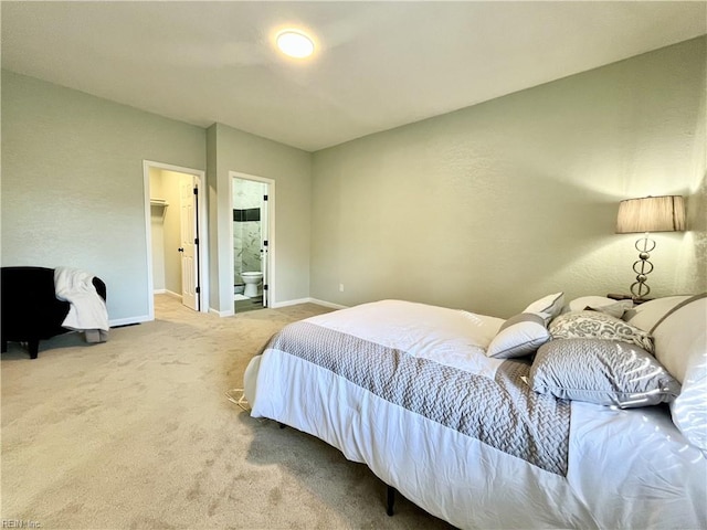 carpeted bedroom featuring a spacious closet and ensuite bathroom