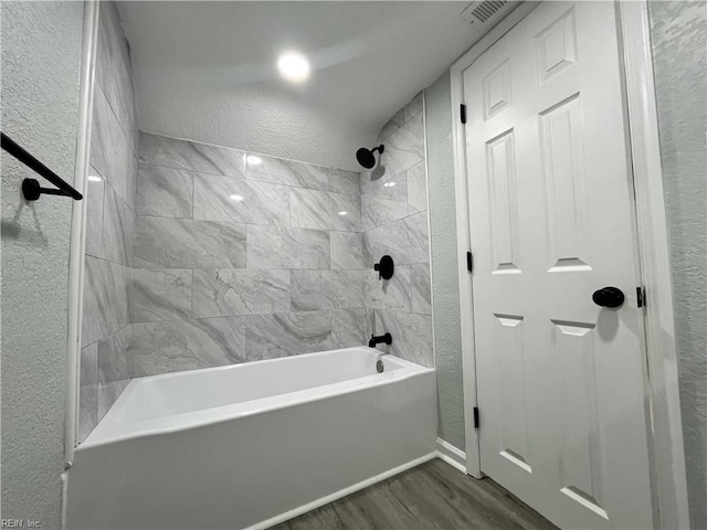 bathroom with tiled shower / bath combo and wood-type flooring