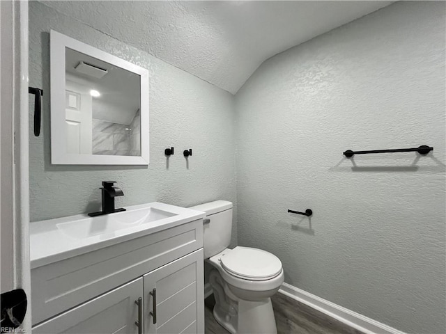 bathroom with vanity, toilet, and hardwood / wood-style floors