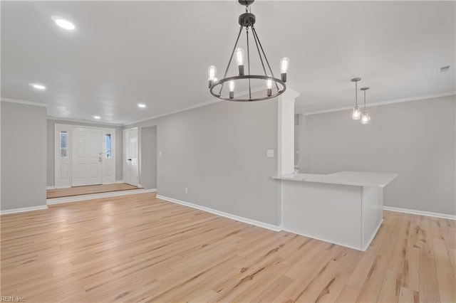 interior space with light wood-type flooring, an inviting chandelier, and ornamental molding