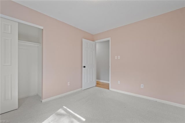 unfurnished bedroom with light carpet and a closet