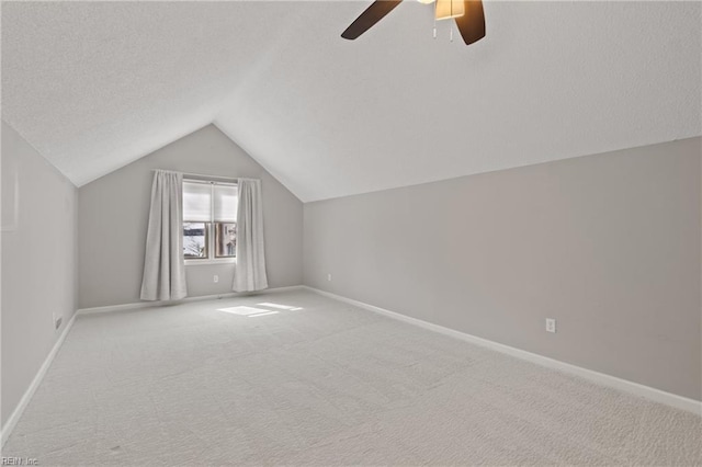 bonus room with a textured ceiling, light carpet, vaulted ceiling, and ceiling fan