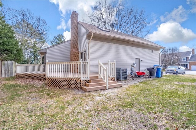 rear view of property featuring a yard, a wooden deck, and central air condition unit