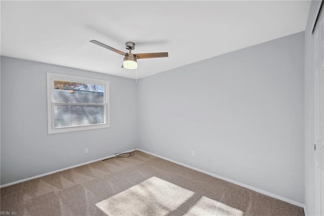 empty room featuring ceiling fan and carpet