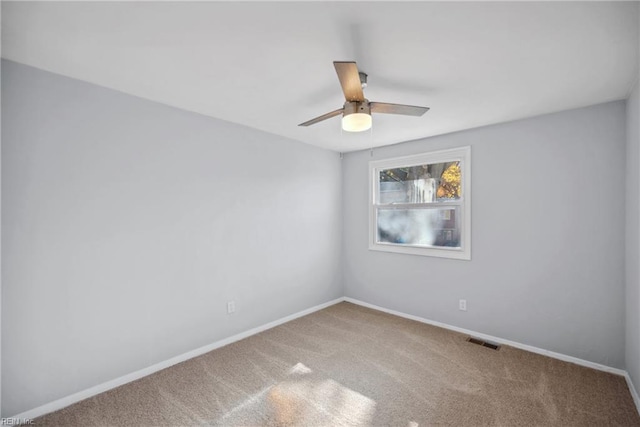 carpeted spare room featuring ceiling fan