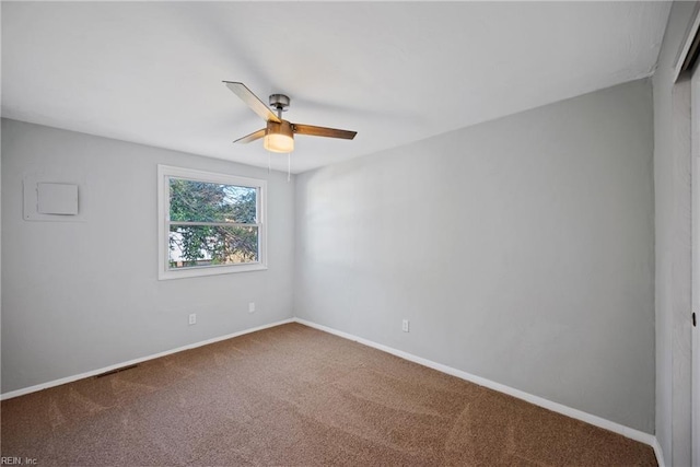 carpeted spare room featuring ceiling fan