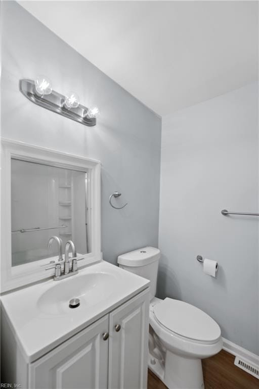 bathroom featuring vanity, toilet, and wood-type flooring