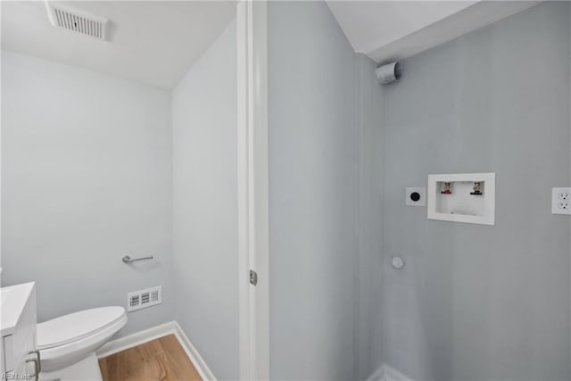 bathroom with vanity, toilet, and hardwood / wood-style floors
