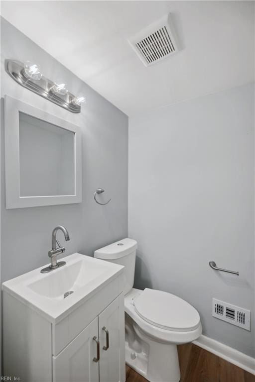 bathroom featuring vanity, hardwood / wood-style floors, and toilet