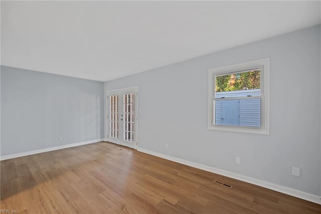 unfurnished room with light wood-type flooring and french doors