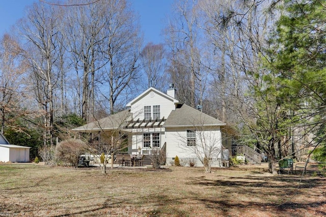 view of front of house with a pergola and a front lawn