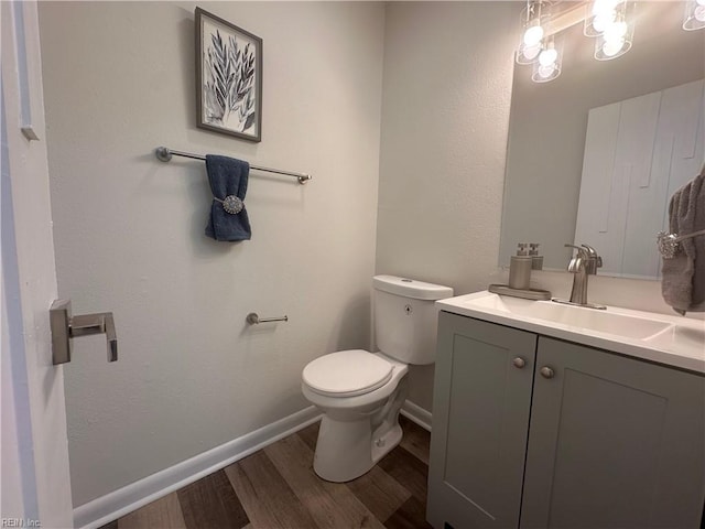 bathroom with hardwood / wood-style flooring, vanity, and toilet