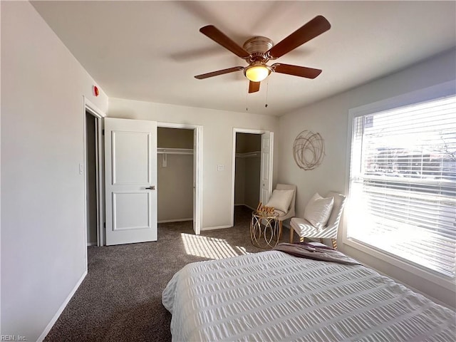 bedroom with multiple closets, ceiling fan, and dark colored carpet