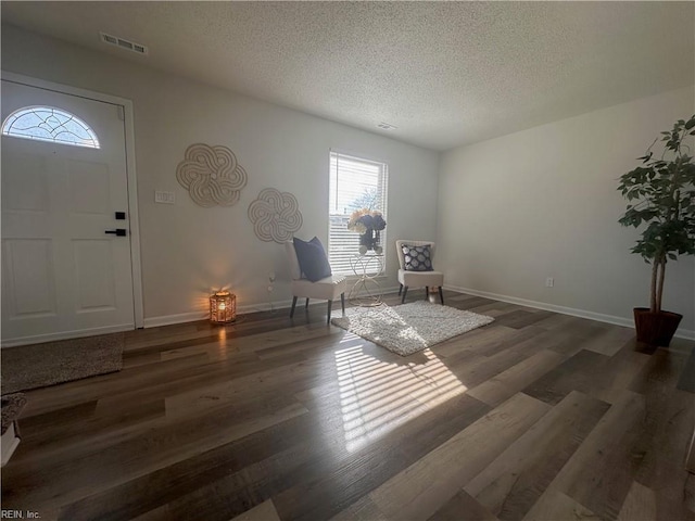 living area with dark wood-type flooring and a textured ceiling