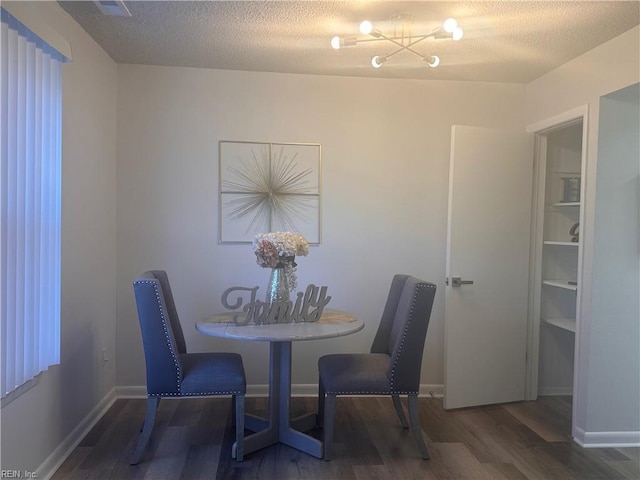 dining room with dark wood-type flooring and a textured ceiling