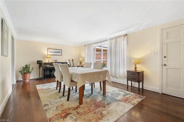 dining room with ornamental molding and dark hardwood / wood-style flooring