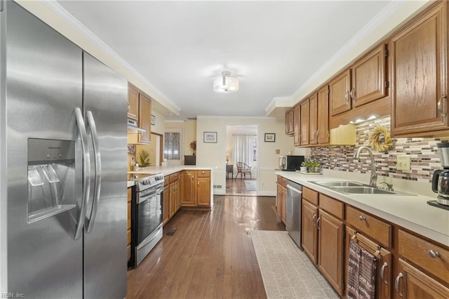 kitchen featuring tasteful backsplash, sink, ornamental molding, stainless steel appliances, and dark wood-type flooring