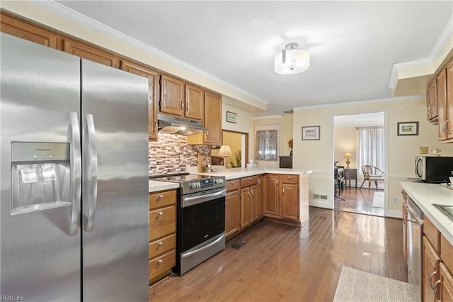 kitchen featuring crown molding, dark hardwood / wood-style flooring, kitchen peninsula, stainless steel appliances, and backsplash