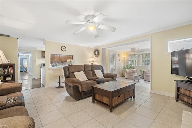 tiled living room with ornamental molding and ceiling fan