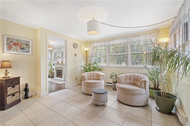 sitting room featuring a baseboard heating unit, ornamental molding, and light tile patterned flooring