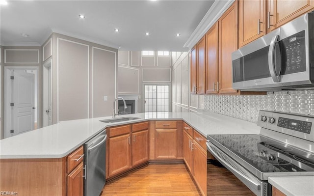 kitchen with sink, backsplash, kitchen peninsula, stainless steel appliances, and light hardwood / wood-style flooring