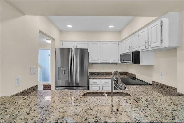 kitchen with appliances with stainless steel finishes, sink, white cabinets, and stone counters