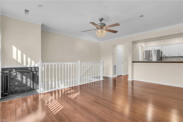 unfurnished living room with sink, ceiling fan, dark hardwood / wood-style floors, and ornamental molding