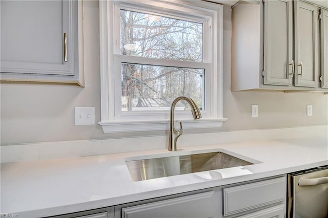 kitchen featuring gray cabinets, dishwasher, plenty of natural light, and sink