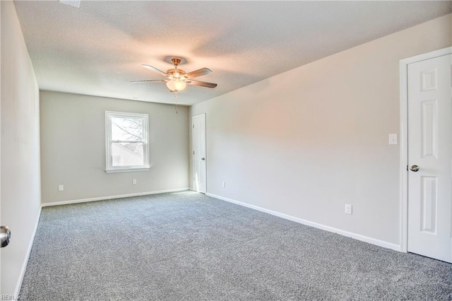 carpeted spare room featuring ceiling fan and a textured ceiling