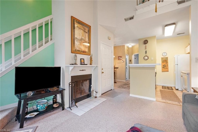 carpeted living room featuring a towering ceiling