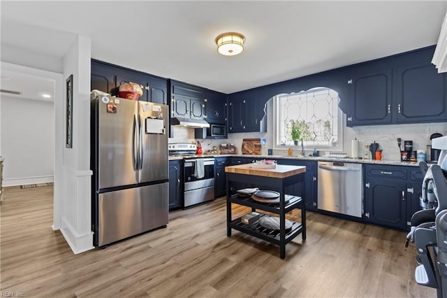 kitchen featuring sink, backsplash, light hardwood / wood-style floors, stainless steel appliances, and blue cabinetry