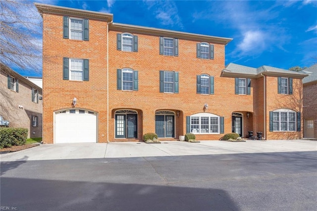 view of front facade with driveway, an attached garage, and brick siding