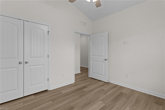 unfurnished bedroom featuring ceiling fan, high vaulted ceiling, a closet, and light wood-type flooring