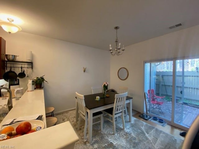 dining area featuring baseboards, visible vents, and a chandelier