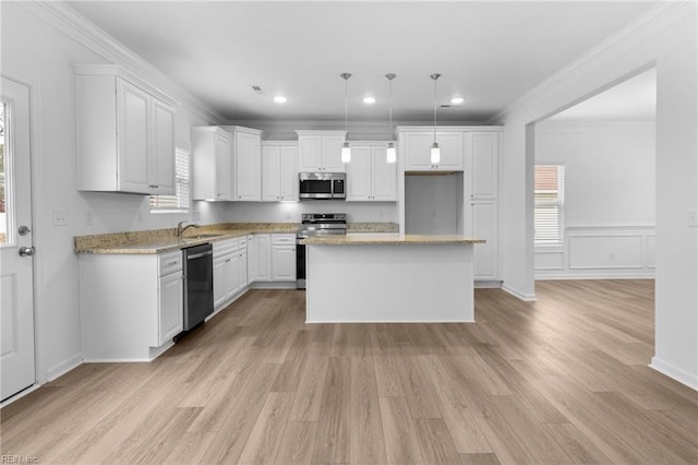 kitchen with pendant lighting, white cabinetry, appliances with stainless steel finishes, and a kitchen island