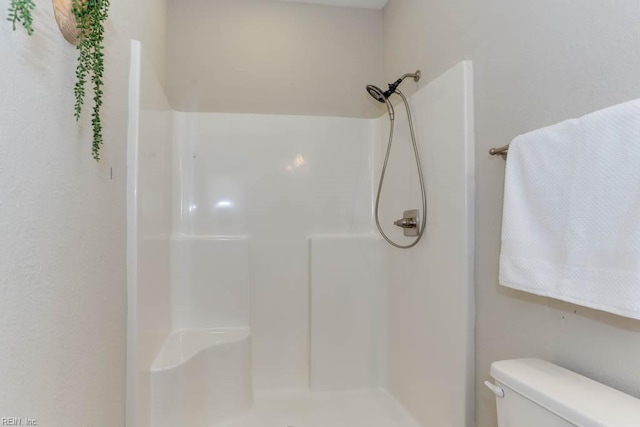 bathroom featuring a shower and toilet