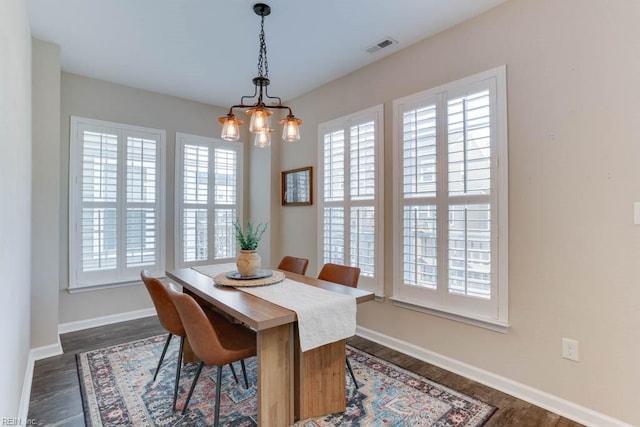 dining area with dark hardwood / wood-style flooring and a notable chandelier