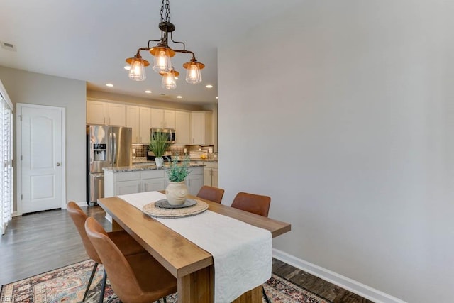 dining space featuring wood-type flooring and a chandelier