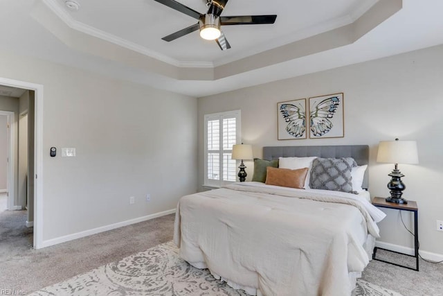 carpeted bedroom featuring ornamental molding, a raised ceiling, and ceiling fan