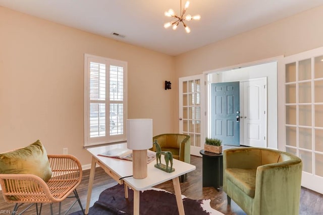 sitting room featuring an inviting chandelier and wood-type flooring